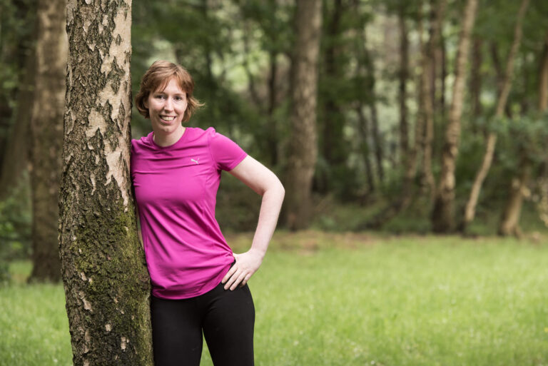 Leonie leunt tegen een boomstam